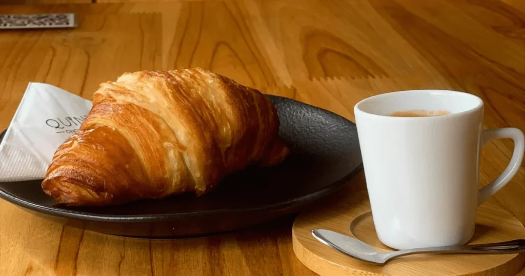 Café e croissant à mesa no Quintal 59